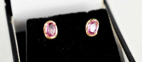 A pair of 18ct gold and pink sapphire earrings, set with oval cut stones of approximately 5.5 by 3.