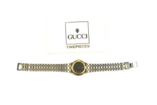 A lady's Gucci wristwatch, the signed black dial with baton numerals, date aperture at 6 o'clock,