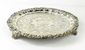 A silver salver, with embossed foliate border, engraved with crest to the centre and motto Deo