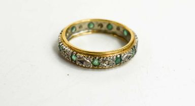 A 9ct gold, diamond and emerald eternity ring, each small emerald adjoined by either an illusion set