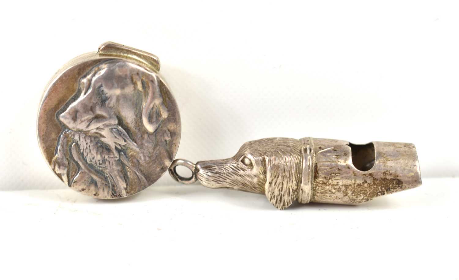 A novelty silver whistle pendant in the form of a dog together with a silver pill box embossed