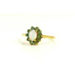 A 9ct gold, opal and emerald ring, of flowerhead form, the oval opal doublet surrounded by ten small