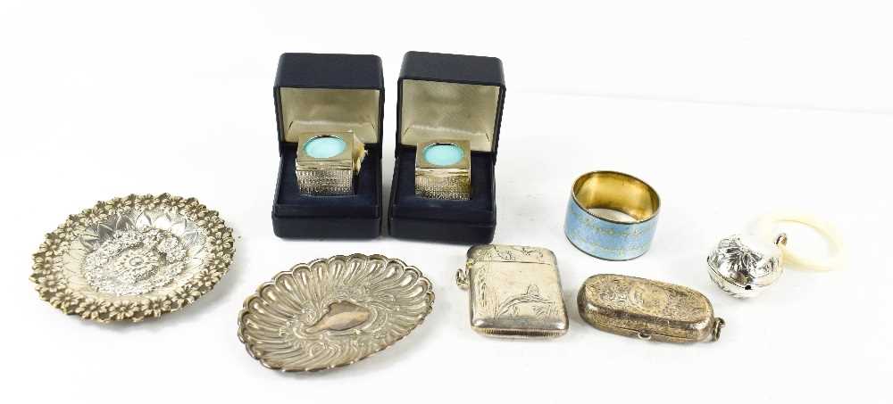 A group of silver to include two embossed trinket dishes, a coin case decorated with chased