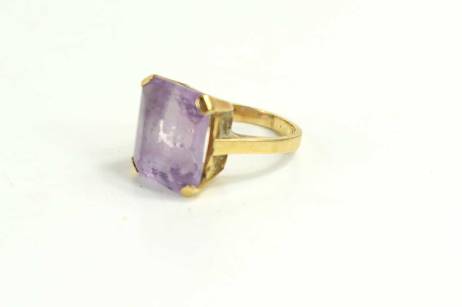A 9ct gold and amethyst dress ring, the emerald cut amethyst of approximately 14 by 12mm, size I/