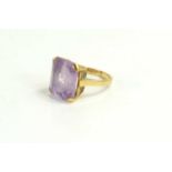 A 9ct gold and amethyst dress ring, the emerald cut amethyst of approximately 14 by 12mm, size I/