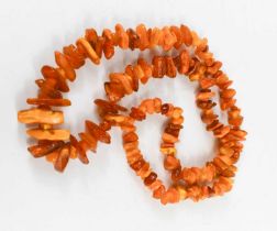 An amber necklace, composed of rough cut graduated amber beads, 123g, 90cm long.