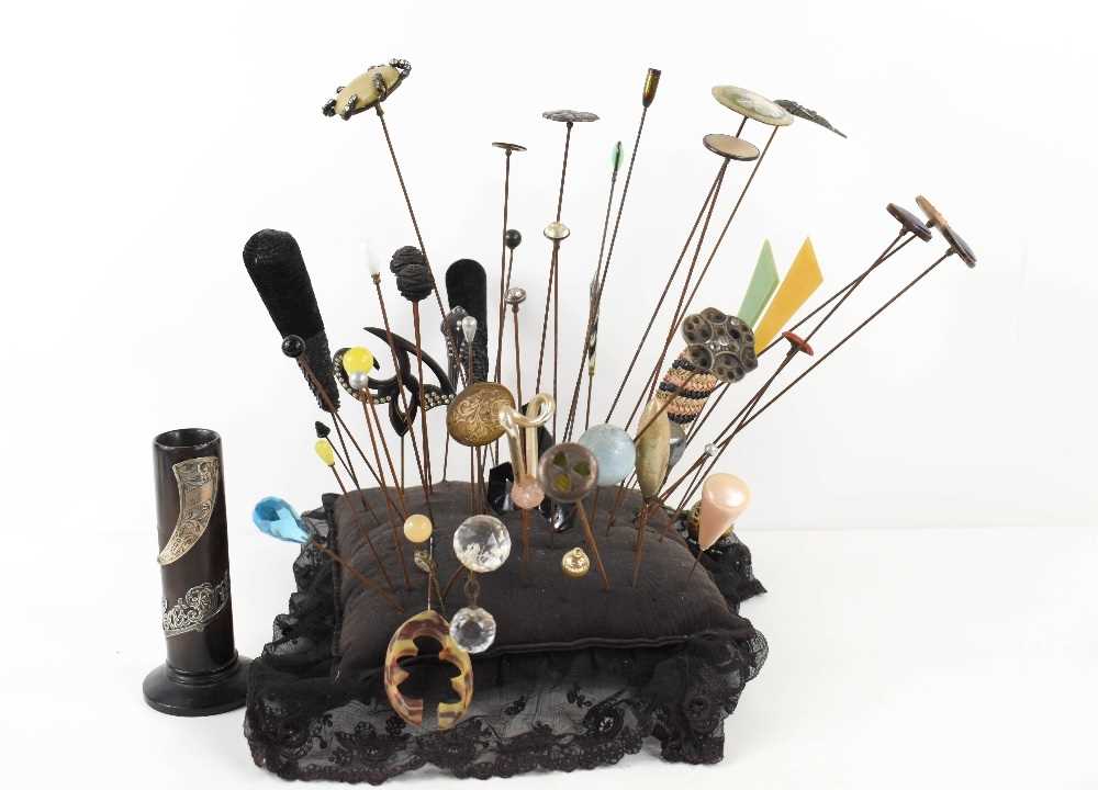 A Victorian pin cushion with thirty eight vintage hat pins of various design, including Art Deco