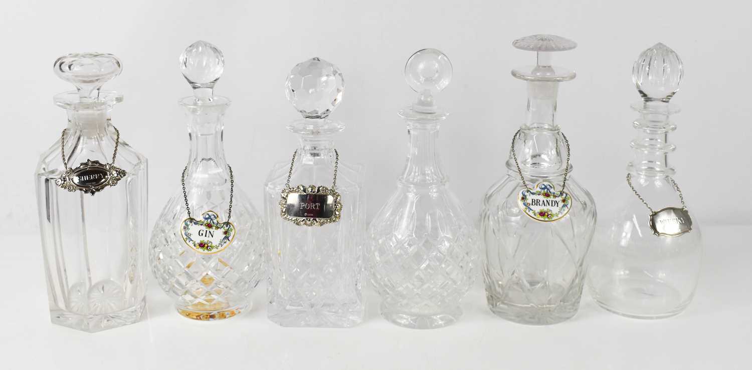 Six cut glass and crystal decanters of various design, together with two porcelain bottle tags for