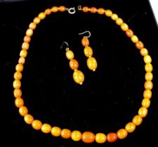 A string of vintage graduated amber beads and matching drop earrings, 21.8g.