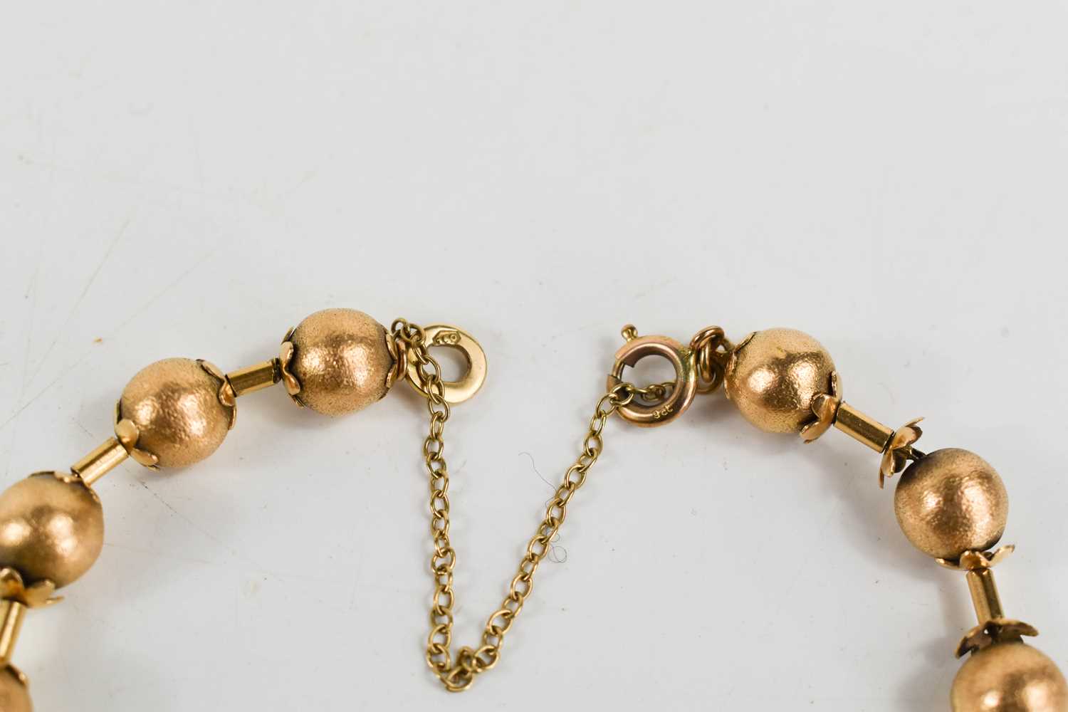 A Victorian gold bracelet of ball and bar form, each ball textured with flower finial to either end, - Image 2 of 3