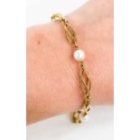 A 9ct gold and pearl bracelet, composed of spiral links interspersed with pearls, with hoop clasp