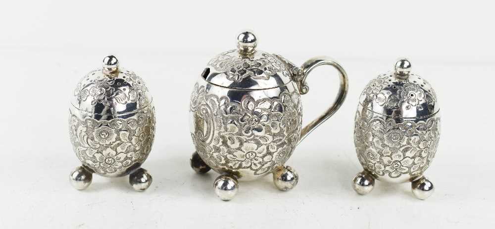 A Victorian silver cruet set comprising a pair of pepperettes and a mustard pot, of ovoid form
