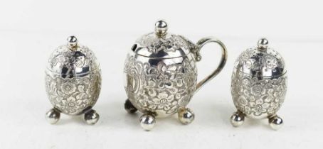 A Victorian silver cruet set comprising a pair of pepperettes and a mustard pot, of ovoid form