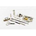 A group of silver grooming accessories including retractable toothpicks, button hook, nail buffer,