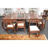 A Chinese hardwood extending dining table with a set of matching dining chairs with cream