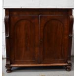 A Victorian mahogany sideboard, the two arched panel doors flanked by carved side supports, raised