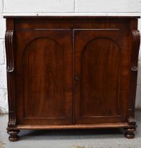 A Victorian mahogany sideboard, the two arched panel doors flanked by carved side supports, raised