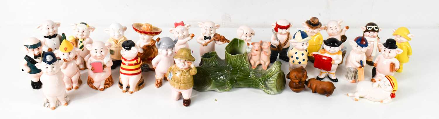 A large group of ceramic 'Piggies', many with original name labels, together with two wooden pig