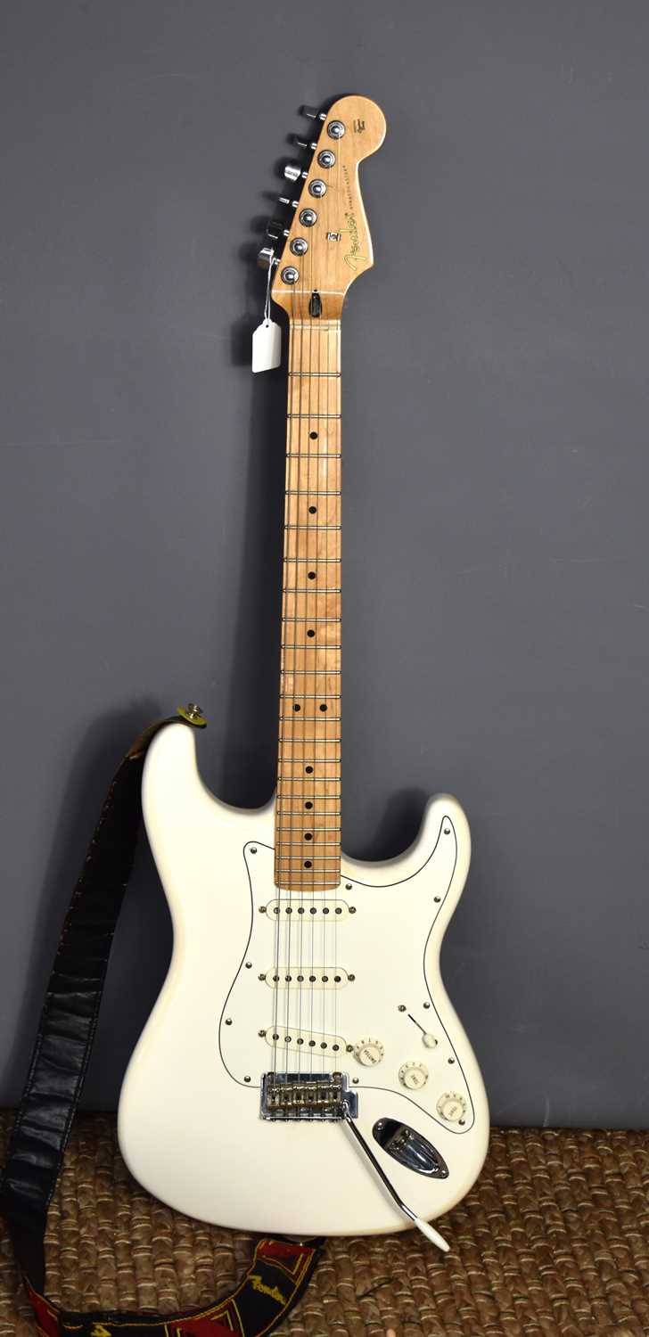 A Fender Stratocaster electric guitar in ivory colour, with maple neck, serial number MX20045453.