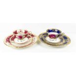 Two Coalport porcelain trios; one with blue ground and one in magenta, with gilded highlights.