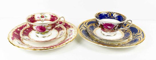 Two Coalport porcelain trios; one with blue ground and one in magenta, with gilded highlights.