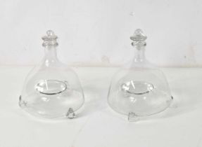 Two 19th century glass fly traps raised on three tapered legs, 21cm tall.