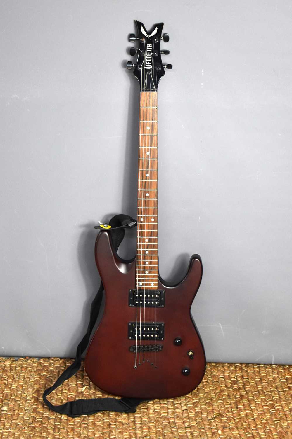 A Dean "Vendetta" electric guitar, burgundy colour, with maple neck.