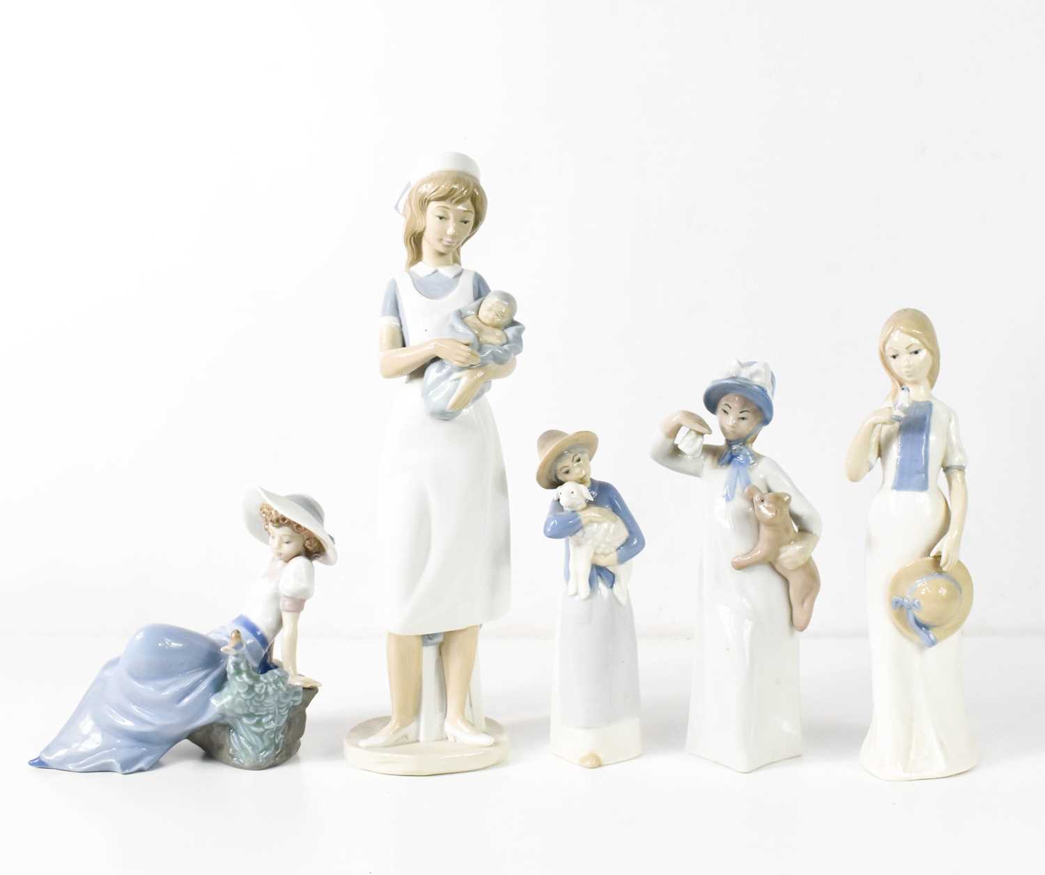 A group of Rex and Nao porcelain figures, comprising Nao nurse and baby and girl with a bird,