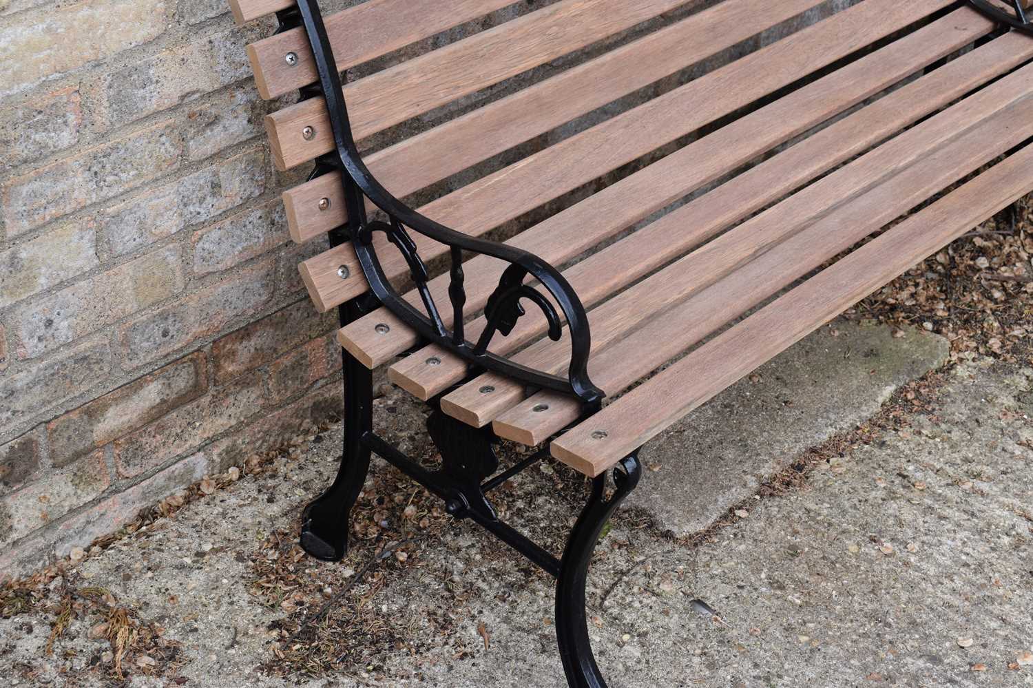 A pair of cast iron benches, painted black with new slats, the cast iron ends of decorative - Image 2 of 2