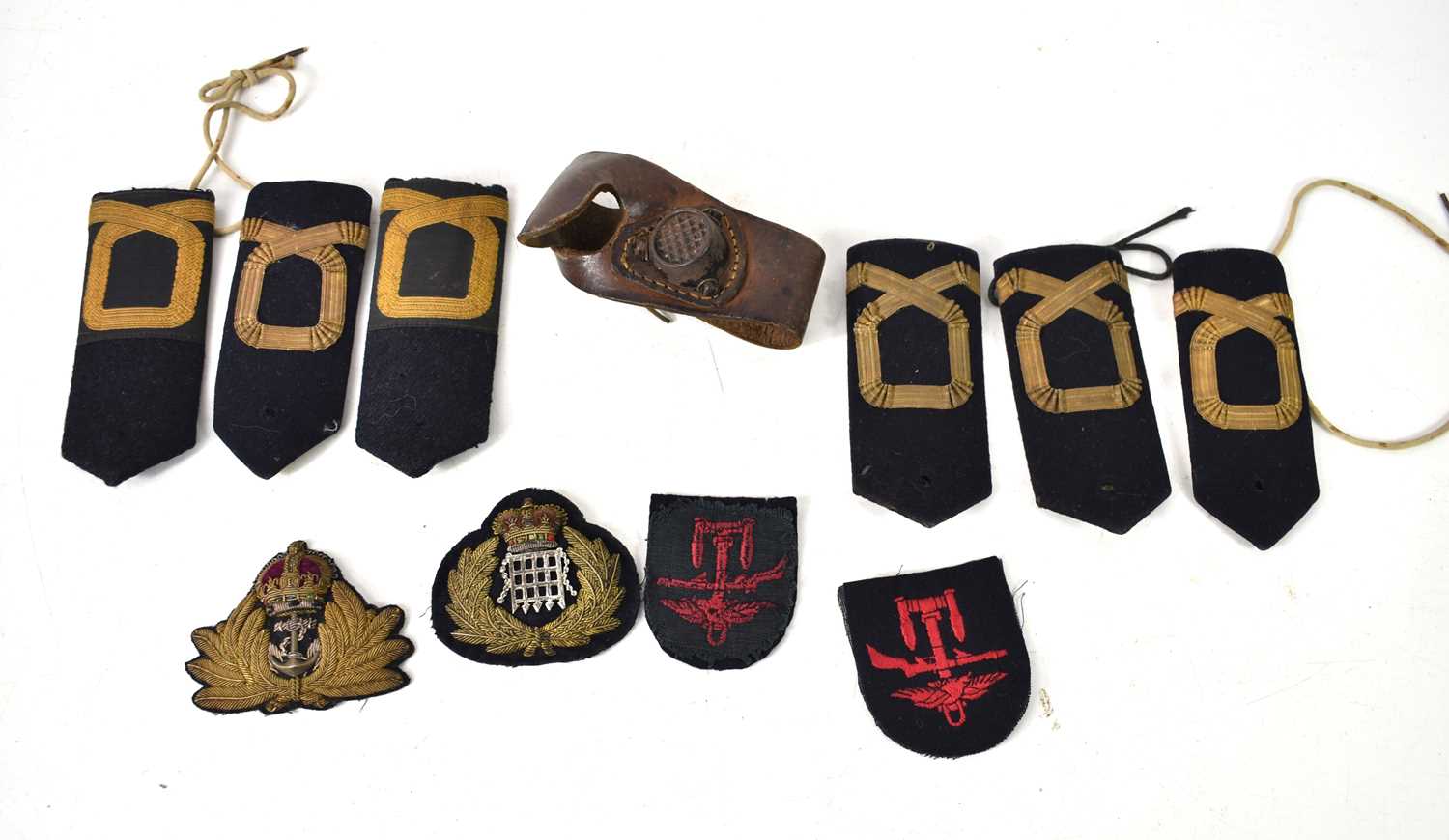 An early 20th century leather sail makers palm together with a Royal Navy officers cap badge, rank