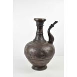 A Persian bronzed metal water vessel, with shaped spout and hammered decoration, likely 19th