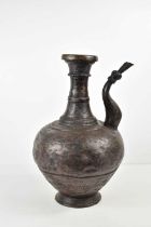 A Persian bronzed metal water vessel, with shaped spout and hammered decoration, likely 19th