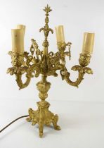 A French gold painted candelabra with four scrolling branches, raising from an urn form column and