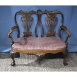 A Queen Anne style settee, with walnut double back, pierced and carved splats, shepherds crook arms,