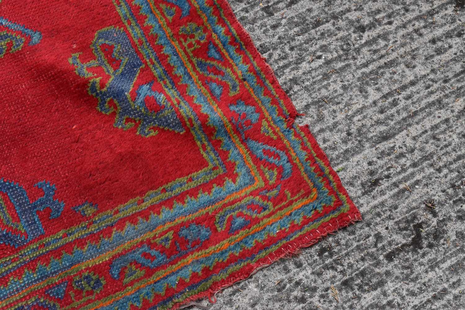 Two antique wool rugs likely Middle Eastern origin both with red ground and stylised motifs and - Image 6 of 13
