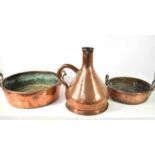 Two large antique copper pans together with a large measure jug, 40cm high.