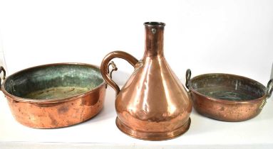 Two large antique copper pans together with a large measure jug, 40cm high.