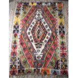 A 19th century Turkish Kilim rug in red, blue, yellow, black and green colours with stylised central