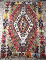 A 19th century Turkish Kilim rug in red, blue, yellow, black and green colours with stylised central