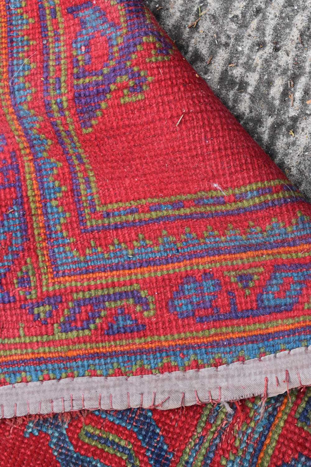 Two antique wool rugs likely Middle Eastern origin both with red ground and stylised motifs and - Image 11 of 13