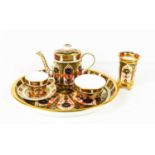 A Royal Crown Derby miniature tea service, comprising tea pot, cup & saucer and sugar bowl, together