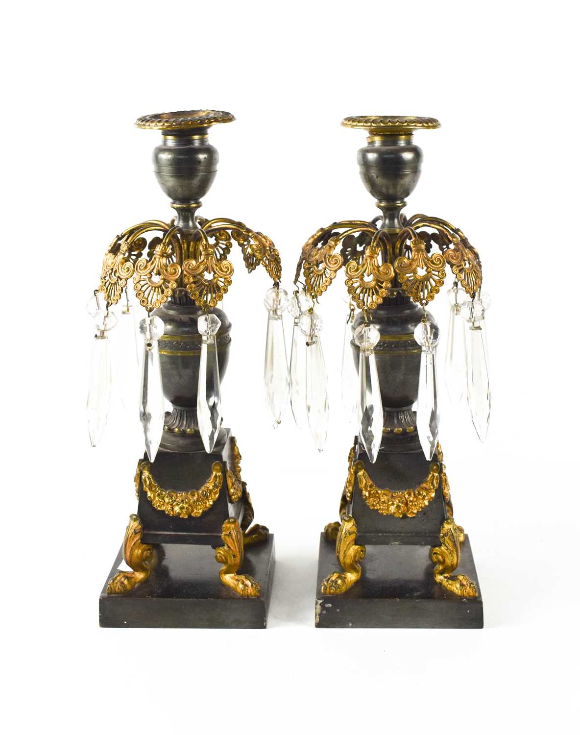 A pair of Empire gilt bronze candlesticks, the candle socket above a pierced and gilded leaf form