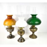 A group of three paraffin lamps, the largest with a green glass shade, and Duplex mechanism, 58cm