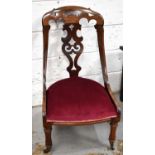 A 19th century Victorian rosewood and mahogany nursing chair with decorative pierced splat and top