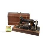 An antique Vesta hand crank sewing machine with original instructions and case.