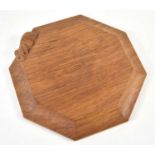 A Robert "Mouseman" Thompson octagonal oak cheeseboard with carved mouse edge, 18.5cm by 18.5cm
