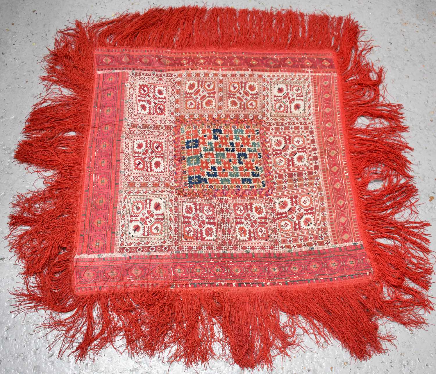 A North Indian embroidered table covering, likely 19th century, having central polychrome coloured