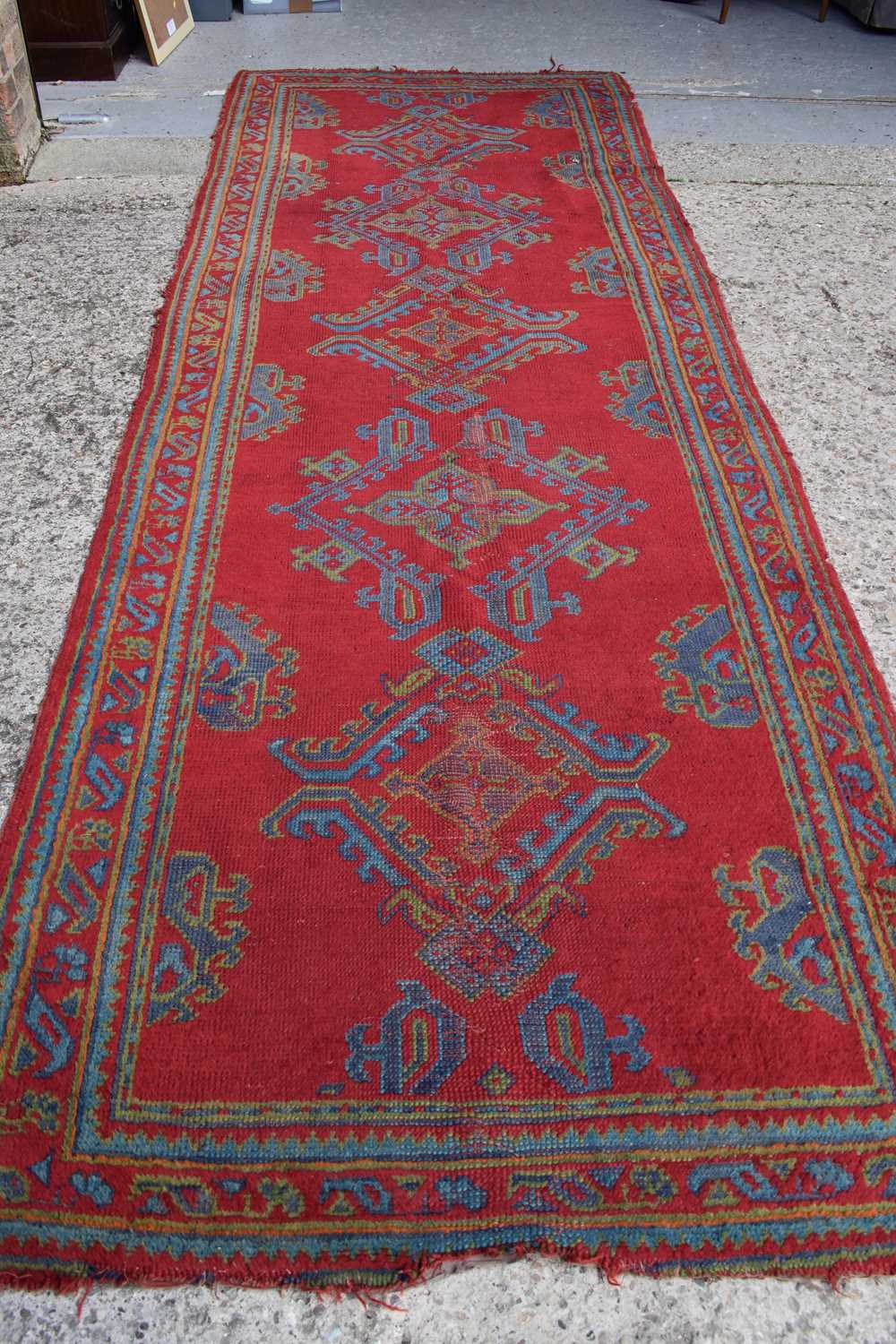 Two antique wool rugs likely Middle Eastern origin both with red ground and stylised motifs and - Image 3 of 13
