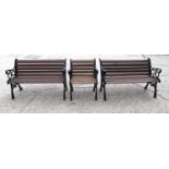 A pair of cast iron garden benches, with later mahogany slats, the cast iron ends of decorative