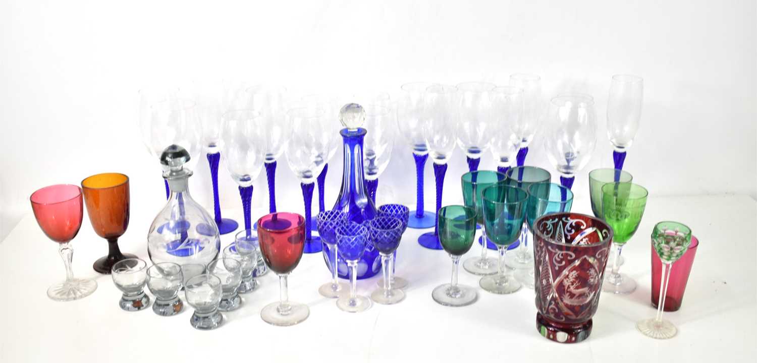 A group of various coloured glasswares, including a number of blue twist stem champagne flutes and